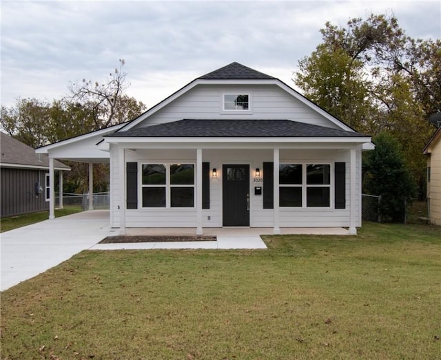 view of front facade featuring covered porch, a front lawn, and a carport