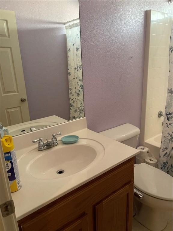 full bathroom with vanity, toilet, and shower / tub combo