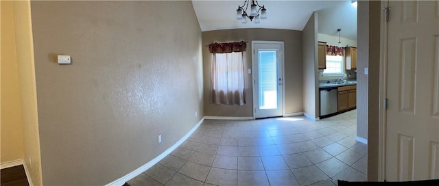 foyer entrance with sink, vaulted ceiling, a notable chandelier, and light tile patterned flooring