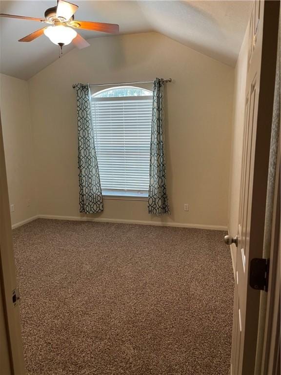 carpeted spare room featuring ceiling fan and lofted ceiling