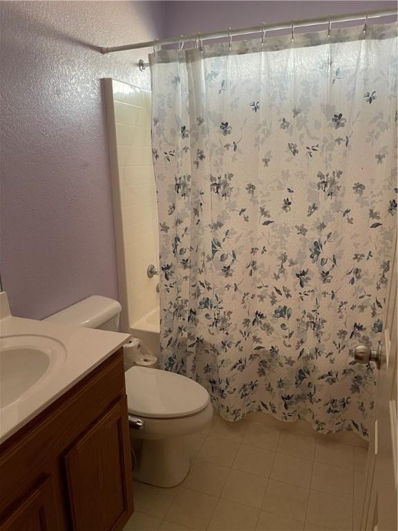 full bathroom featuring tile patterned flooring, vanity, toilet, and shower / bathtub combination with curtain