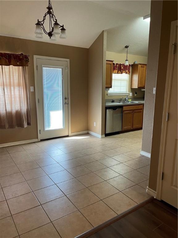 kitchen with dishwasher, light tile patterned floors, decorative light fixtures, and a chandelier