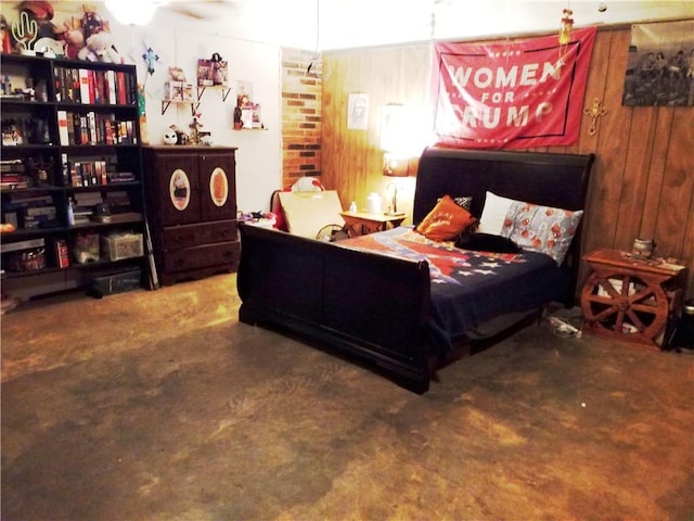 bedroom with wood walls and concrete flooring