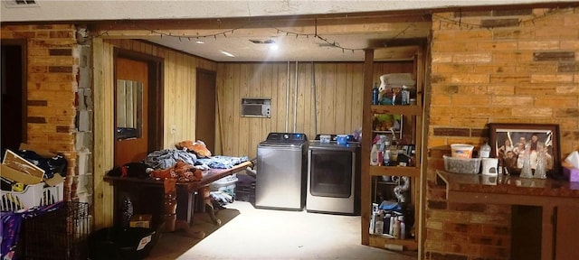 laundry room featuring wood walls and washing machine and clothes dryer