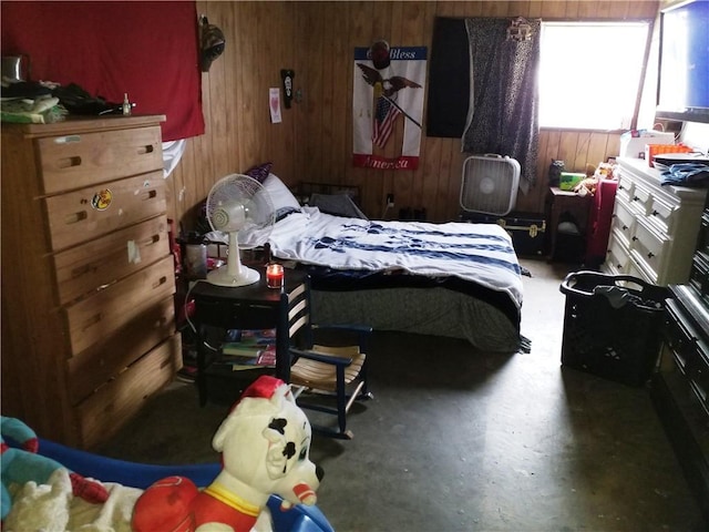 bedroom featuring wood walls and concrete flooring