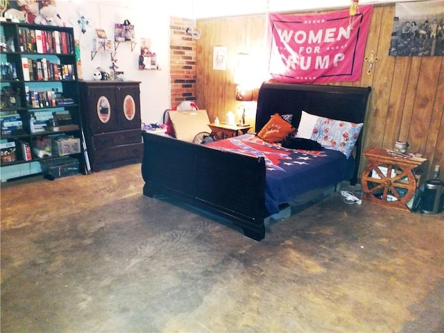 bedroom featuring wood walls and concrete flooring