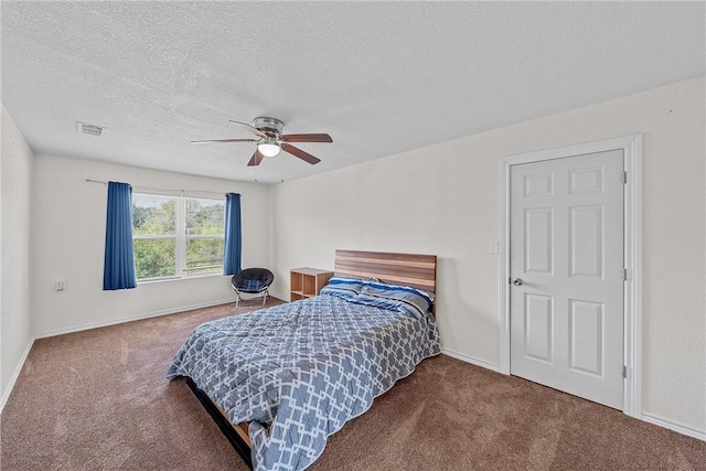 carpeted bedroom with ceiling fan and a textured ceiling