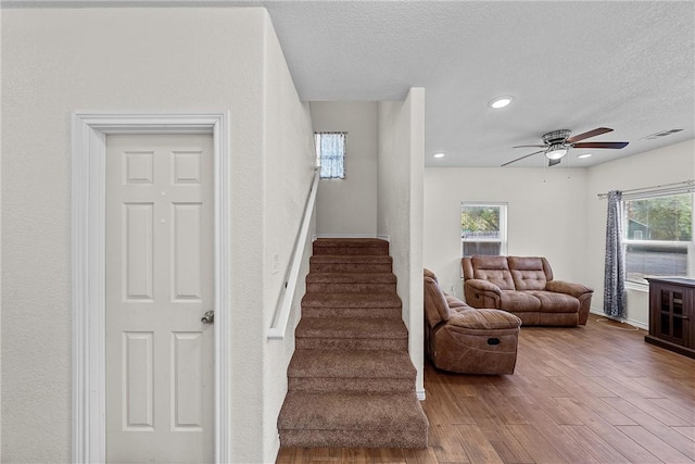 interior space with hardwood / wood-style flooring, ceiling fan, and a textured ceiling