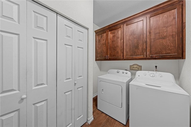 laundry room with dark hardwood / wood-style floors, cabinets, a textured ceiling, and washing machine and clothes dryer