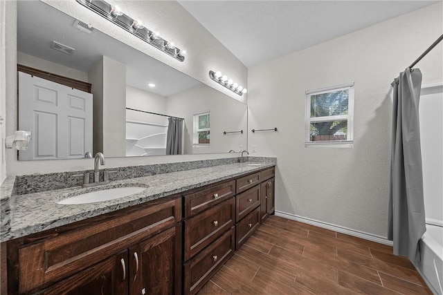 bathroom with vanity, shower / tub combo with curtain, and plenty of natural light