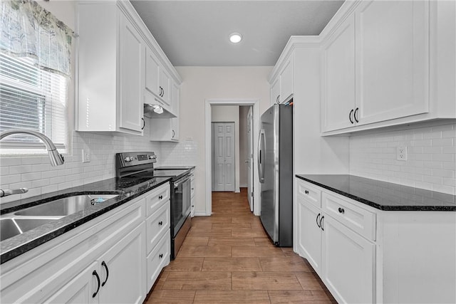 kitchen featuring white cabinets, stainless steel appliances, light hardwood / wood-style floors, and sink