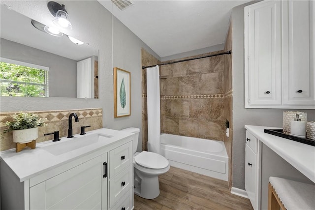 full bathroom featuring shower / bath combo with shower curtain, vanity, wood-type flooring, and toilet