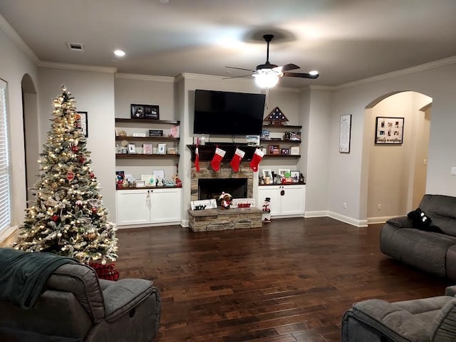 living room featuring a fireplace, ceiling fan, dark hardwood / wood-style flooring, and crown molding