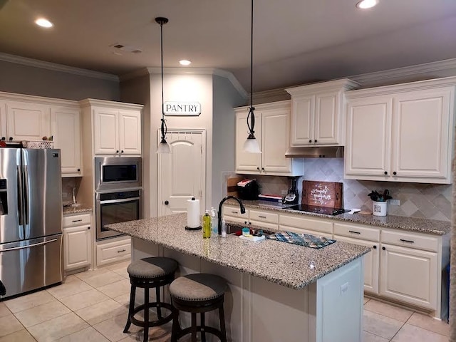 kitchen with white cabinets, appliances with stainless steel finishes, and an island with sink