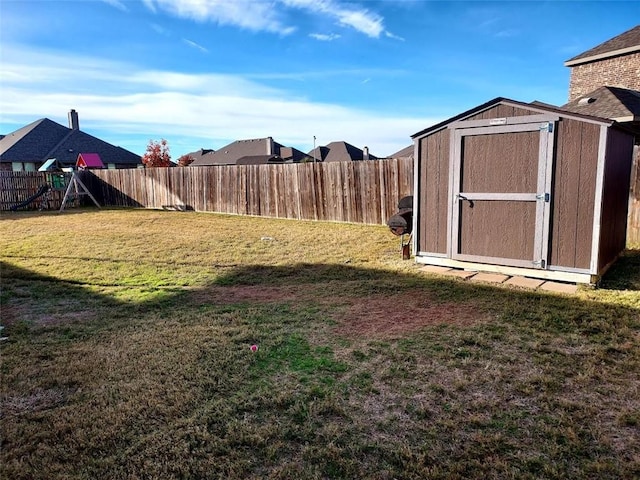 view of yard with a playground and a storage shed