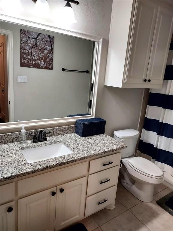 bathroom featuring tile patterned flooring, vanity, and toilet