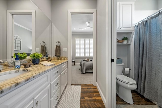 ensuite bathroom with a sink, toilet, and ornamental molding