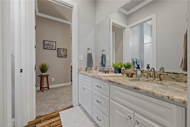 full bathroom with a sink, baseboards, wood finished floors, and double vanity