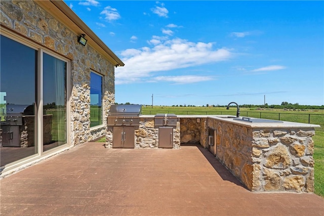 view of patio with area for grilling, fence, and grilling area