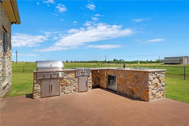 view of patio / terrace with grilling area, an outdoor kitchen, a sink, and fence