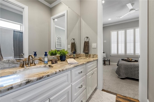 ensuite bathroom with a sink, double vanity, visible vents, and ornamental molding