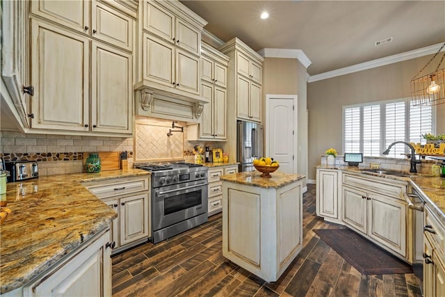 kitchen featuring visible vents, a sink, cream cabinetry, crown molding, and premium appliances