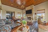 living room with wood ceiling, a fireplace, and an inviting chandelier