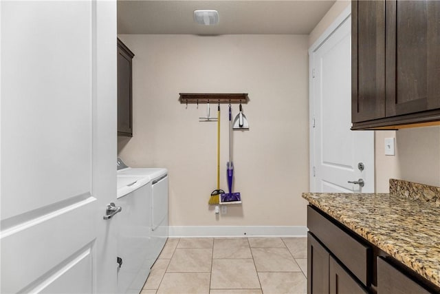 laundry room featuring washer and dryer, light tile patterned floors, and cabinets