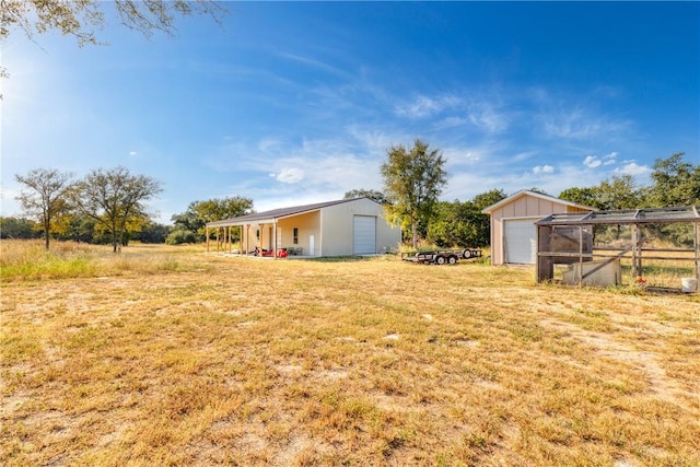 view of yard with a garage and an outdoor structure