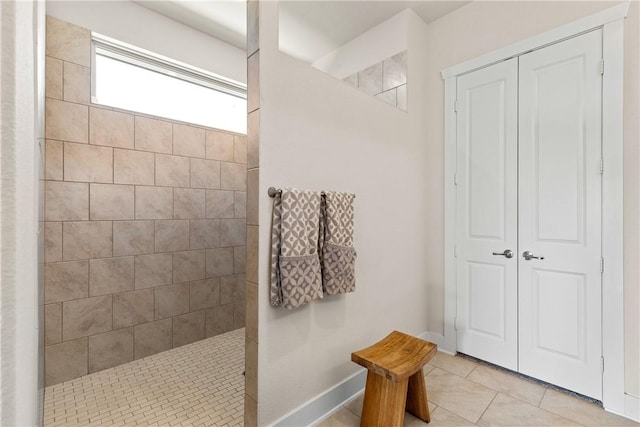 bathroom with tile patterned flooring and a tile shower