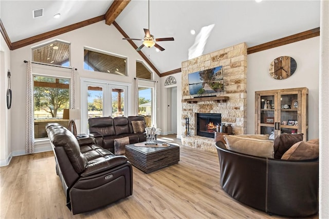 living room featuring french doors, a fireplace, high vaulted ceiling, and light wood-type flooring