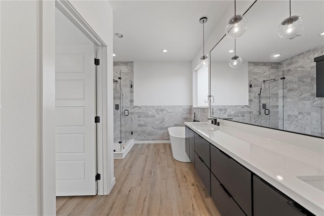 bathroom with vanity, plus walk in shower, tile walls, and hardwood / wood-style flooring