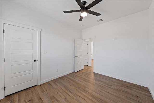 unfurnished bedroom featuring hardwood / wood-style floors and ceiling fan