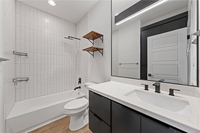 full bathroom featuring tiled shower / bath combo, toilet, wood-type flooring, and vanity