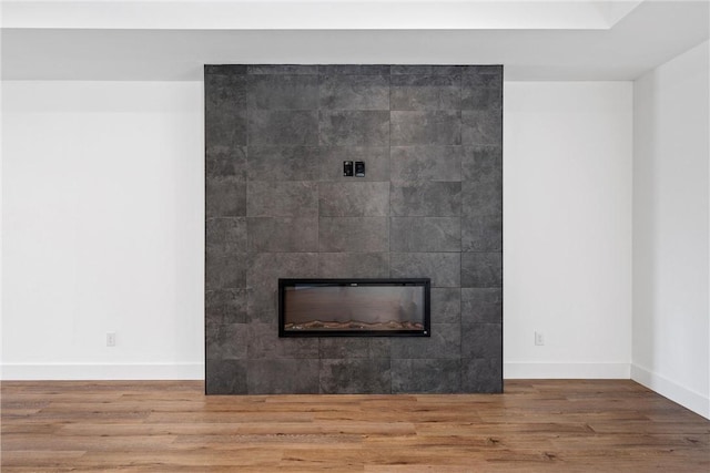 details featuring a tile fireplace and hardwood / wood-style flooring