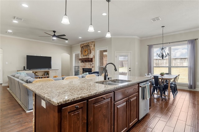 kitchen featuring dishwasher, a stone fireplace, visible vents, and a sink