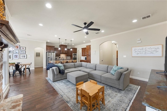 living room with visible vents, arched walkways, dark wood-type flooring, and ceiling fan