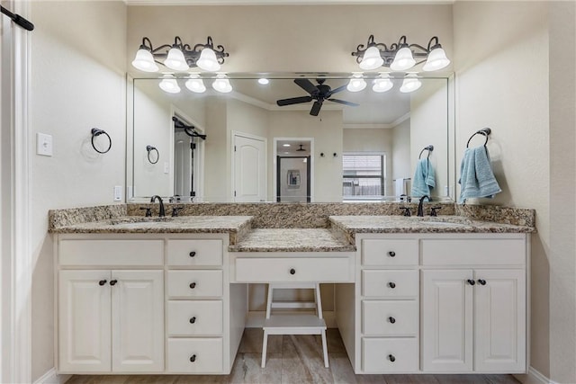 full bathroom featuring double vanity, crown molding, ceiling fan, and a sink