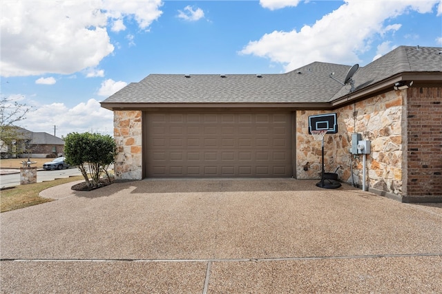 view of front of property with concrete driveway, an attached garage, stone siding, and roof with shingles