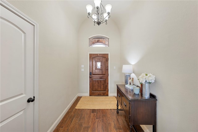 foyer featuring an inviting chandelier, dark wood-type flooring, and baseboards