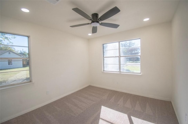 carpeted spare room featuring ceiling fan