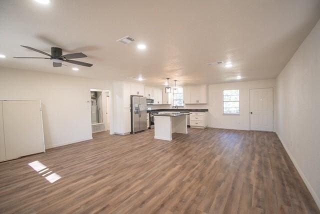 unfurnished living room featuring ceiling fan and wood-type flooring