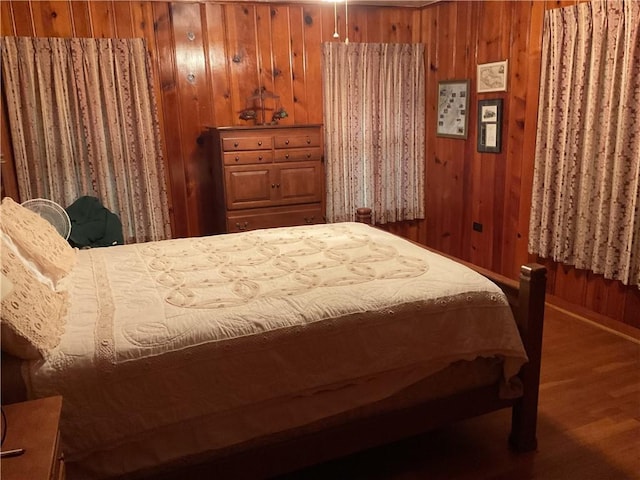 bedroom with wood walls and wood-type flooring