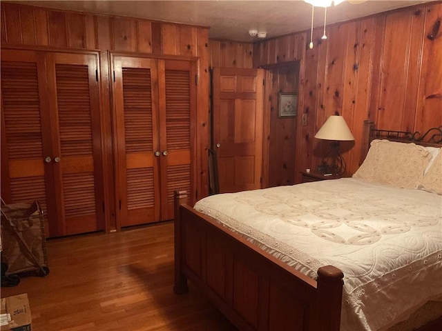 bedroom featuring hardwood / wood-style flooring and wood walls