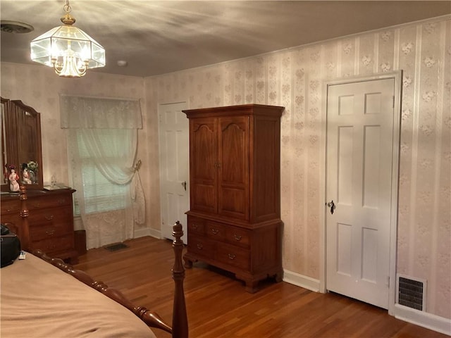 bedroom with a chandelier and wood-type flooring