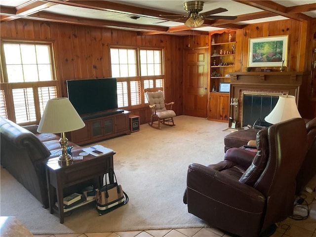 carpeted living room featuring a wealth of natural light, beamed ceiling, wood walls, and ceiling fan