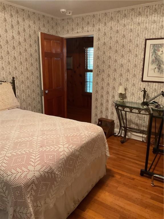 bedroom featuring hardwood / wood-style floors and ornamental molding