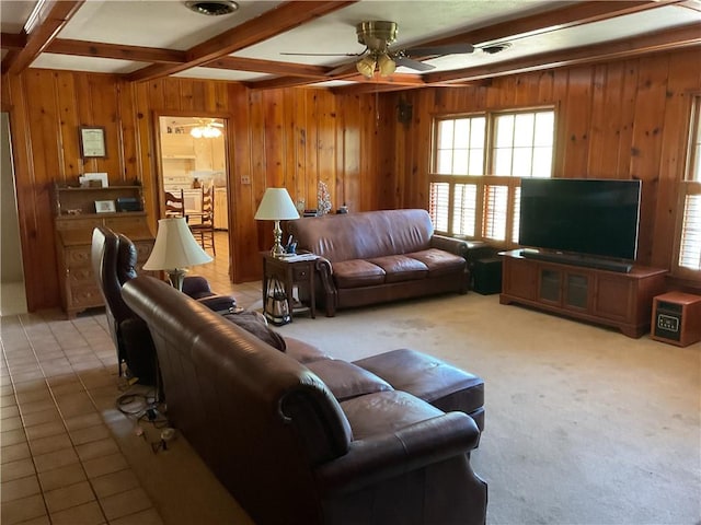 living room with beamed ceiling, tile patterned flooring, ceiling fan, and wood walls