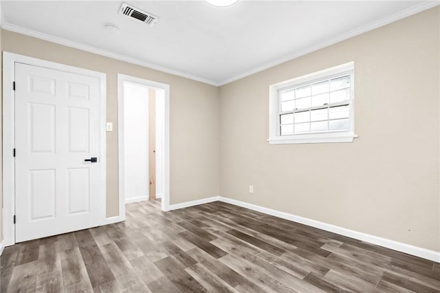 empty room with ornamental molding and dark wood-type flooring