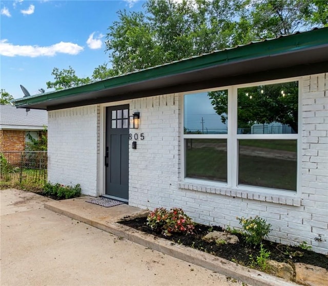 view of exterior entry with a patio